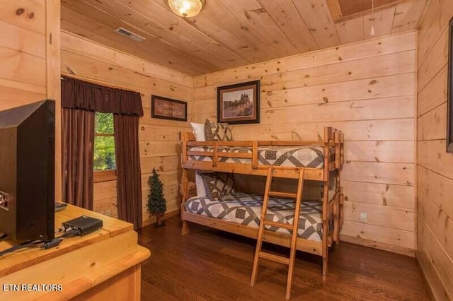 bedroom featuring dark wood finished floors, wood ceiling, and wood walls