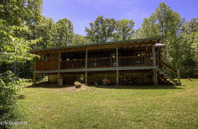back of property with a yard and stairs