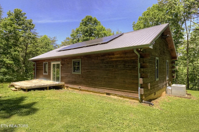 back of property with crawl space, a lawn, and solar panels