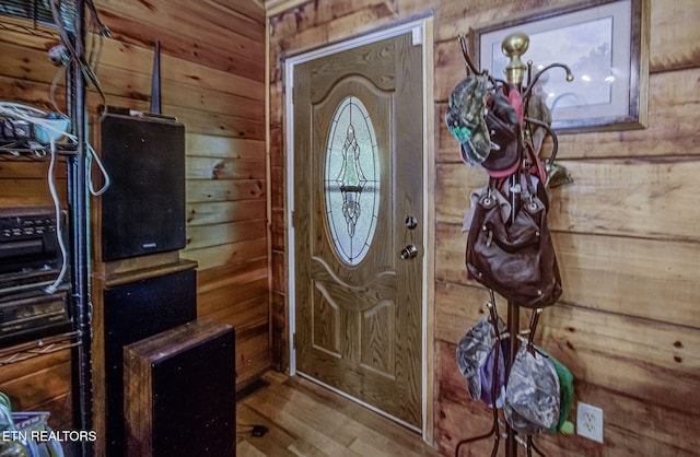 foyer featuring wooden walls and wood finished floors