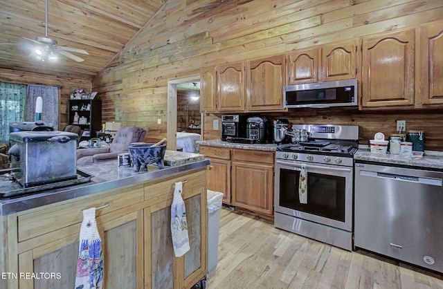 kitchen featuring appliances with stainless steel finishes, lofted ceiling, light wood finished floors, wooden ceiling, and a ceiling fan