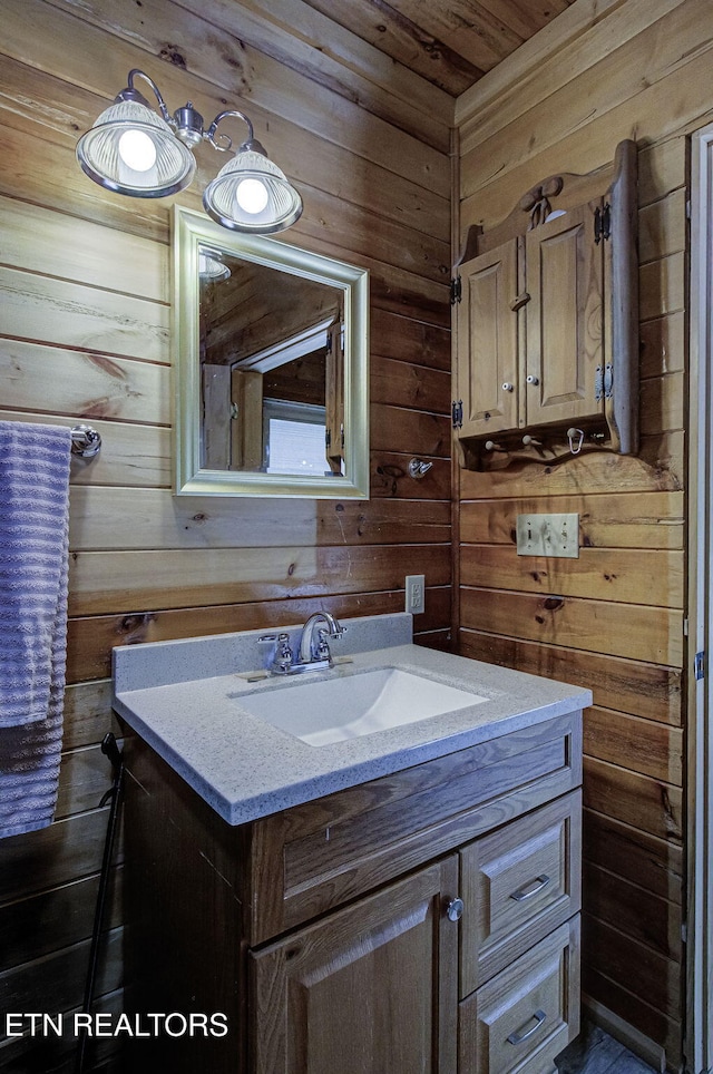 bathroom with wood walls, vanity, and wooden ceiling
