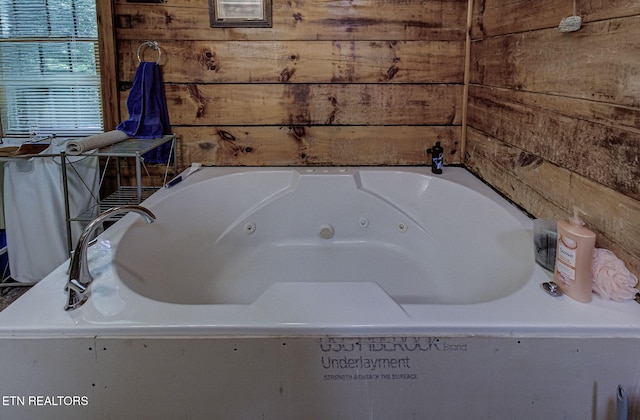 full bathroom featuring wooden walls and a whirlpool tub