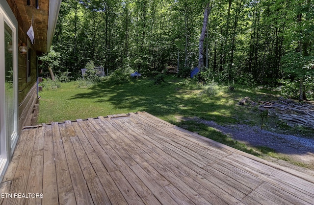 wooden terrace featuring a lawn