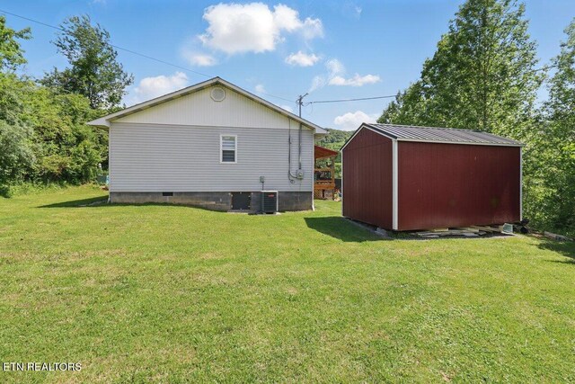 164 Walker Ln, Middlesboro, KY 40965 - back of property featuring a lawn, an outbuilding, a storage shed, and central AC