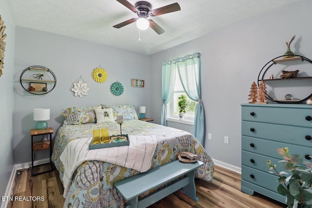 164 Walker Ln, Middlesboro, KY 40965 - bedroom featuring wood finished floors, a textured ceiling, a ceiling fan, and baseboards