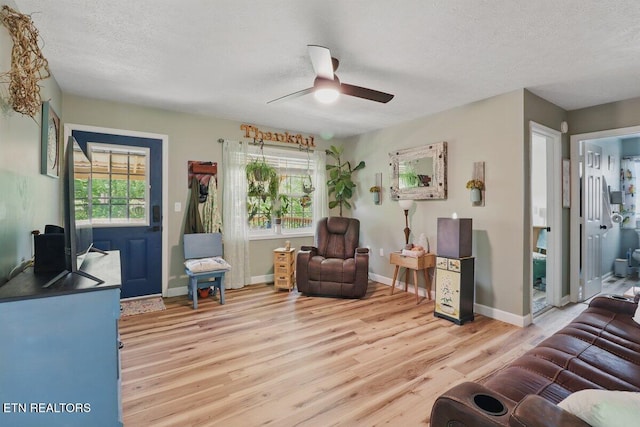 164 Walker Ln, Middlesboro, KY 40965 - living room featuring light wood-style floors, ceiling fan, plenty of natural light, a textured ceiling, and baseboards