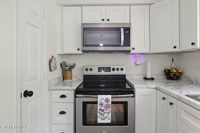 164 Walker Ln, Middlesboro, KY 40965 - kitchen with stainless steel appliances, white cabinetry, and light stone countertops