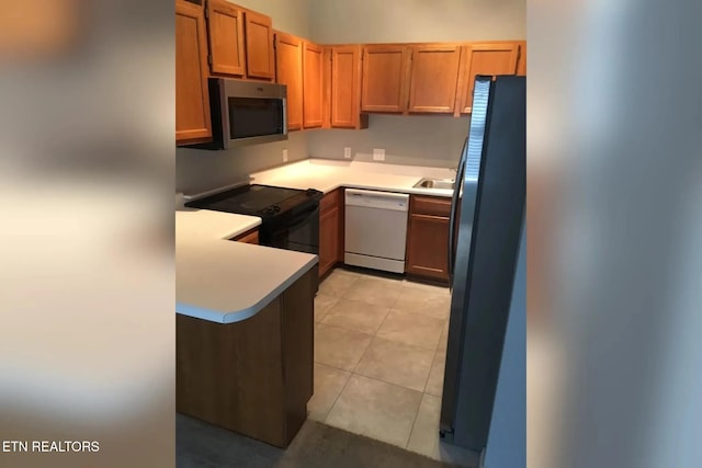 10008 Greylock Way, Knoxville, TN 37931 - kitchen with black appliances, light countertops, a peninsula, a sink, and brown cabinets