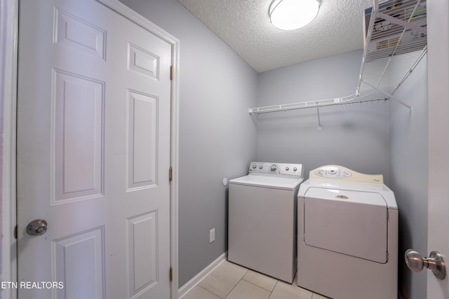 10008 Greylock Way, Knoxville, TN 37931 - washroom with washing machine and dryer, a textured ceiling, light tile patterned floors, and baseboards