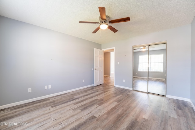 10008 Greylock Way, Knoxville, TN 37931 - unfurnished bedroom with wood finished floors, a closet, baseboards, a textured ceiling, and ceiling fan