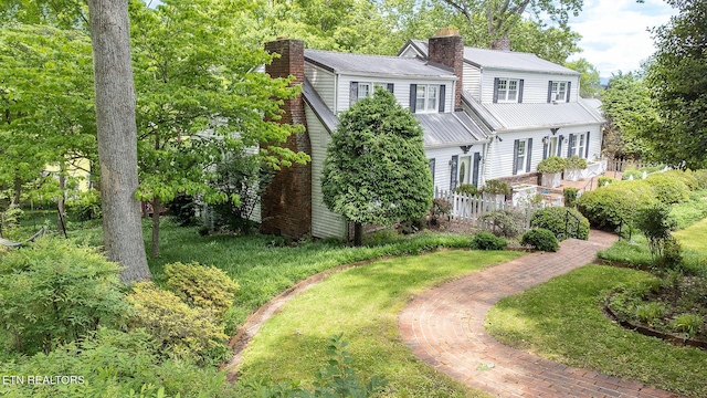 view of front of house featuring a chimney and metal roof