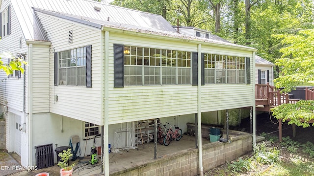 view of side of home with metal roof and a deck
