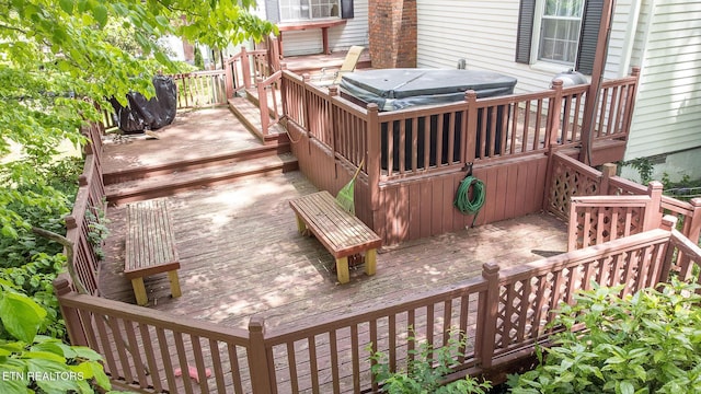 wooden deck featuring a hot tub and stairway