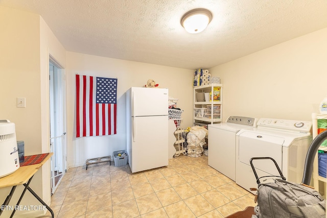 clothes washing area featuring a textured ceiling and light tile patterned flooring