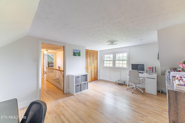 office featuring light wood-type flooring and a textured ceiling