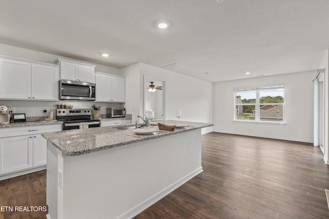 7813 Night Shade Ln, Knoxville, TN 37938 - kitchen with appliances with stainless steel finishes, a sink, dark wood-style floors, white cabinets, and light stone counters