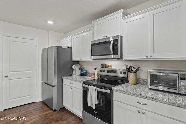 7813 Night Shade Ln, Knoxville, TN 37938 - kitchen with stainless steel appliances, white cabinetry, light stone counters, dark wood-style flooring, and recessed lighting