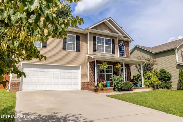 332 Caboose Ln, Maryville, TN 37804 - traditional-style house with brick siding, an attached garage, concrete driveway, a front lawn, and covered porch