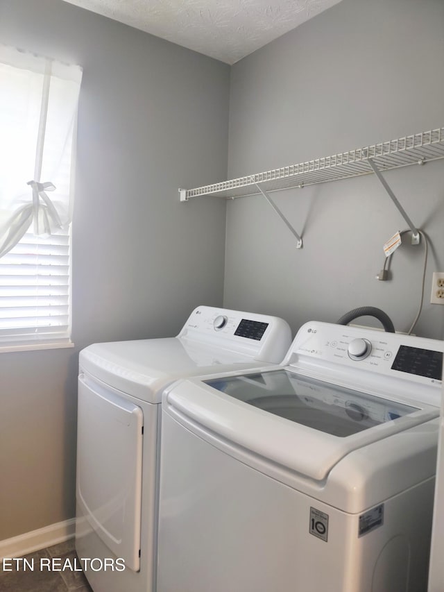 laundry area featuring washer and clothes dryer and baseboards
