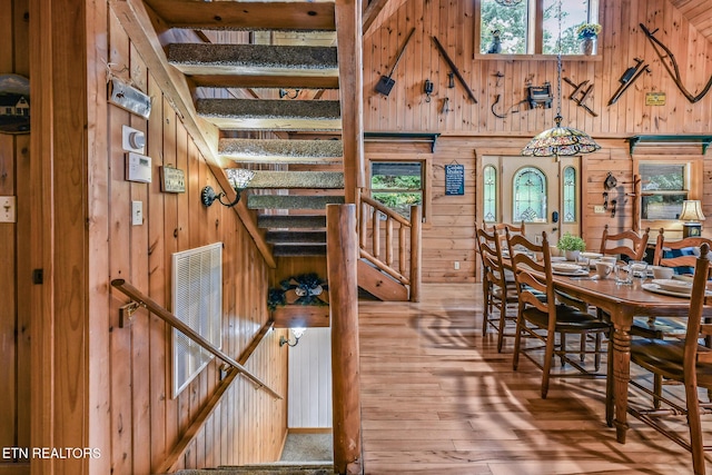 813 Pine Top Ln, Gatlinburg, TN 37738 - dining room with wooden walls, stairs, hardwood / wood-style flooring, and a towering ceiling