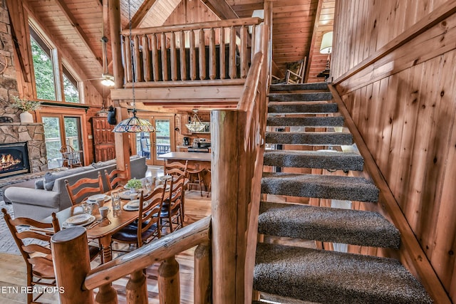 813 Pine Top Ln, Gatlinburg, TN 37738 - stairway with wood ceiling with exposed beams, wooden walls, plenty of natural light, high vaulted ceiling, and a fireplace
