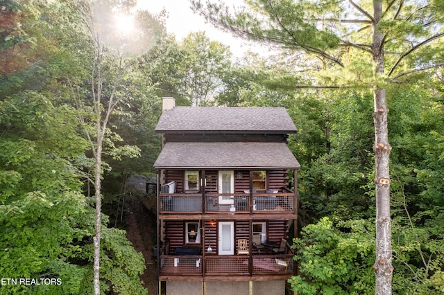 4186 Evans Chapel Rd, Sevierville, TN 37876 - view of front facade with a chimney, log exterior, a shingled roof, a balcony, and a wooden deck