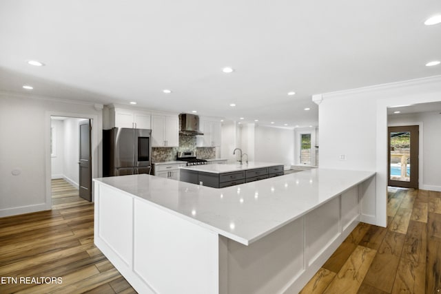 520 S David Ln, Knoxville, TN 37922 - kitchen with appliances with stainless steel finishes, wall chimney range hood, a large island with sink, recessed lighting, and wood finished floors
