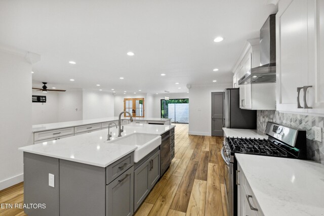 520 S David Ln, Knoxville, TN 37922 - kitchen with stainless steel appliances, wall chimney exhaust hood, a sink, light wood-type flooring, and recessed lighting