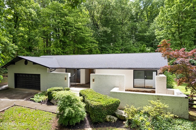 520 S David Ln, Knoxville, TN 37922 - view of front of property featuring brick siding, a fenced front yard, concrete driveway, roof with shingles, and a garage