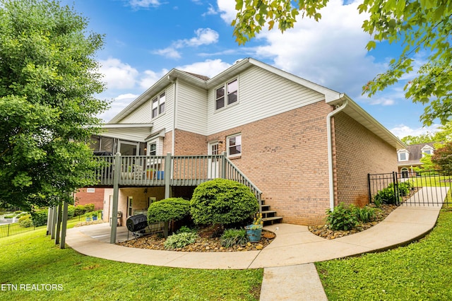back of property with brick siding, a deck, and stairs