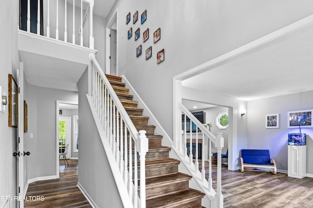 stairway with wood finished floors and baseboards