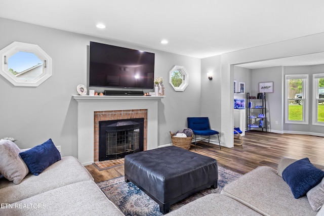 living area with wood finished floors, a fireplace, recessed lighting, and baseboards