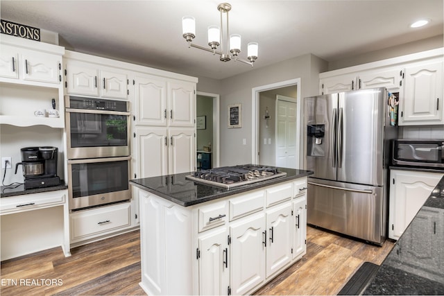 kitchen with appliances with stainless steel finishes, white cabinetry, dark stone counters, a chandelier, and recessed lighting