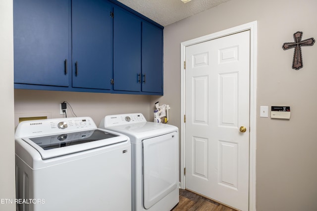 washroom featuring cabinet space, washer and clothes dryer, dark wood-style floors, and a textured ceiling