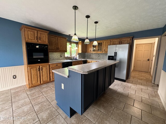 721 Fan St, Tazewell, TN 37879 - kitchen featuring black appliances, decorative backsplash, a kitchen island, brown cabinetry, and a textured ceiling