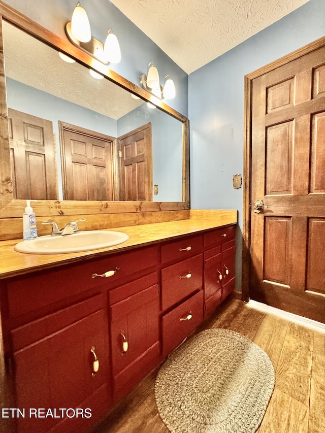 721 Fan St, Tazewell, TN 37879 - bathroom featuring wood finished floors, vanity, and a textured ceiling
