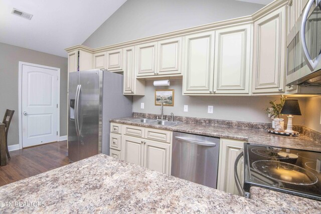 155 Signet Ln, Maynardville, TN 37807 - kitchen with cream cabinets, appliances with stainless steel finishes, a sink, dark wood-type flooring, and vaulted ceiling