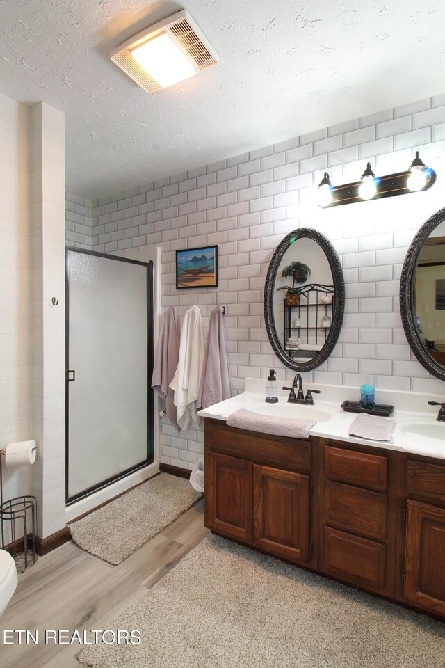 4708 Springbrook Rd, Knoxville, TN 37921 - full bath with wood finished floors, a shower stall, a textured ceiling, double vanity, and carpet flooring