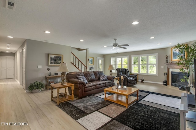 162 Tanasi Lagoon Dr, Loudon, TN 37774 - living room with light wood-style floors, a ceiling fan, baseboards, stairway, and a textured ceiling