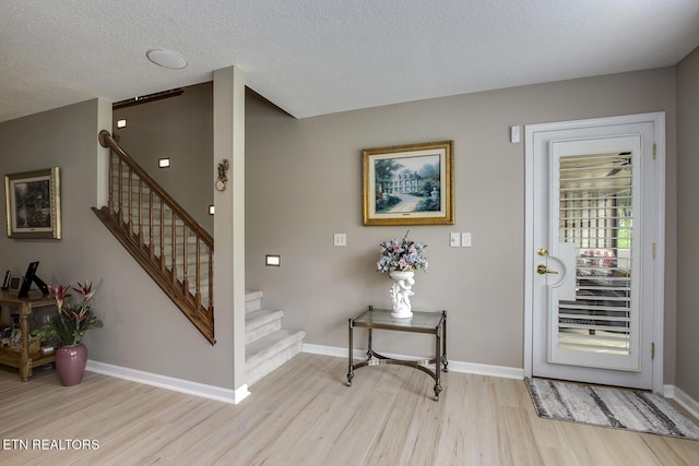 162 Tanasi Lagoon Dr, Loudon, TN 37774 - entryway featuring light wood finished floors, stairway, baseboards, and a textured ceiling