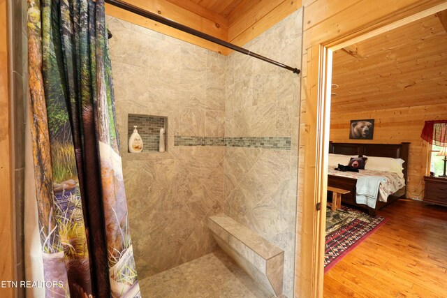 2266 Lone Ridge Dr, Sevierville, TN 37862 - bathroom with tiled shower, wood walls, wood finished floors, connected bathroom, and wood ceiling