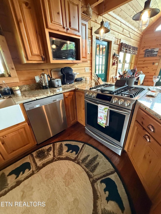 2266 Lone Ridge Dr, Sevierville, TN 37862 - kitchen featuring stainless steel appliances, wood walls, dark wood-style floors, lofted ceiling, and light stone counters