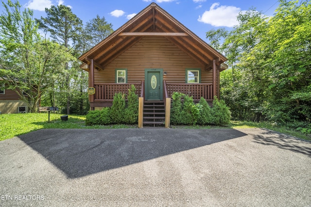 chalet / cabin with a porch and log veneer siding