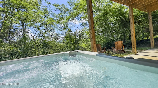 view of swimming pool with a hot tub