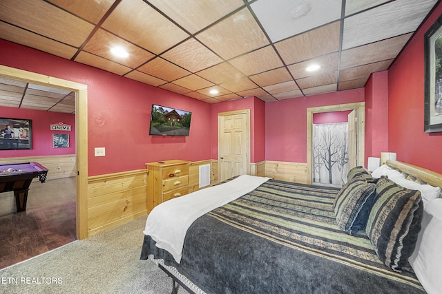bedroom with wainscoting, wood walls, a paneled ceiling, and carpet floors