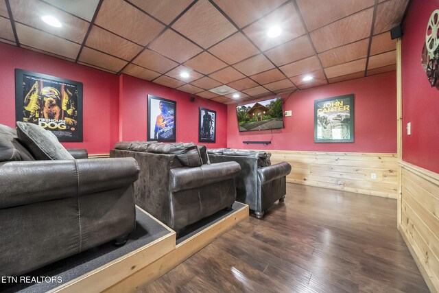 home theater featuring a wainscoted wall, wood finished floors, and a drop ceiling