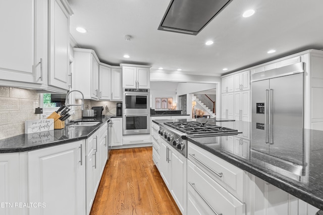 kitchen featuring a sink, stainless steel appliances, white cabinets, recessed lighting, and tasteful backsplash
