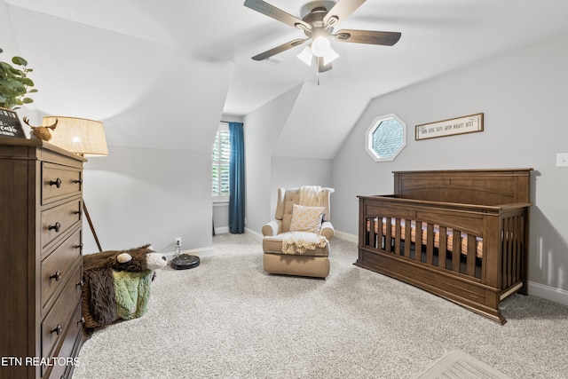 bedroom with carpet flooring, lofted ceiling, baseboards, and a crib