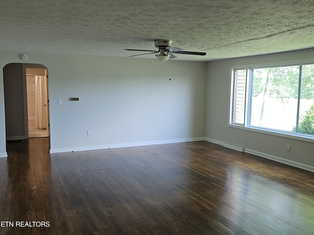 335 Bristol Rd, Harrogate, TN 37752 - unfurnished room featuring arched walkways, ceiling fan, dark wood finished floors, baseboards, and a textured ceiling